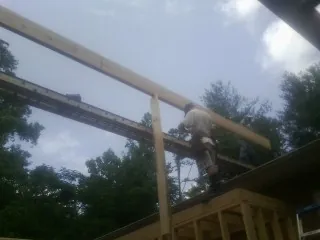 Carpenter setting a ridge beam over a new addition frame — Ice Dam Removal by Roofing Brothers in Bixby