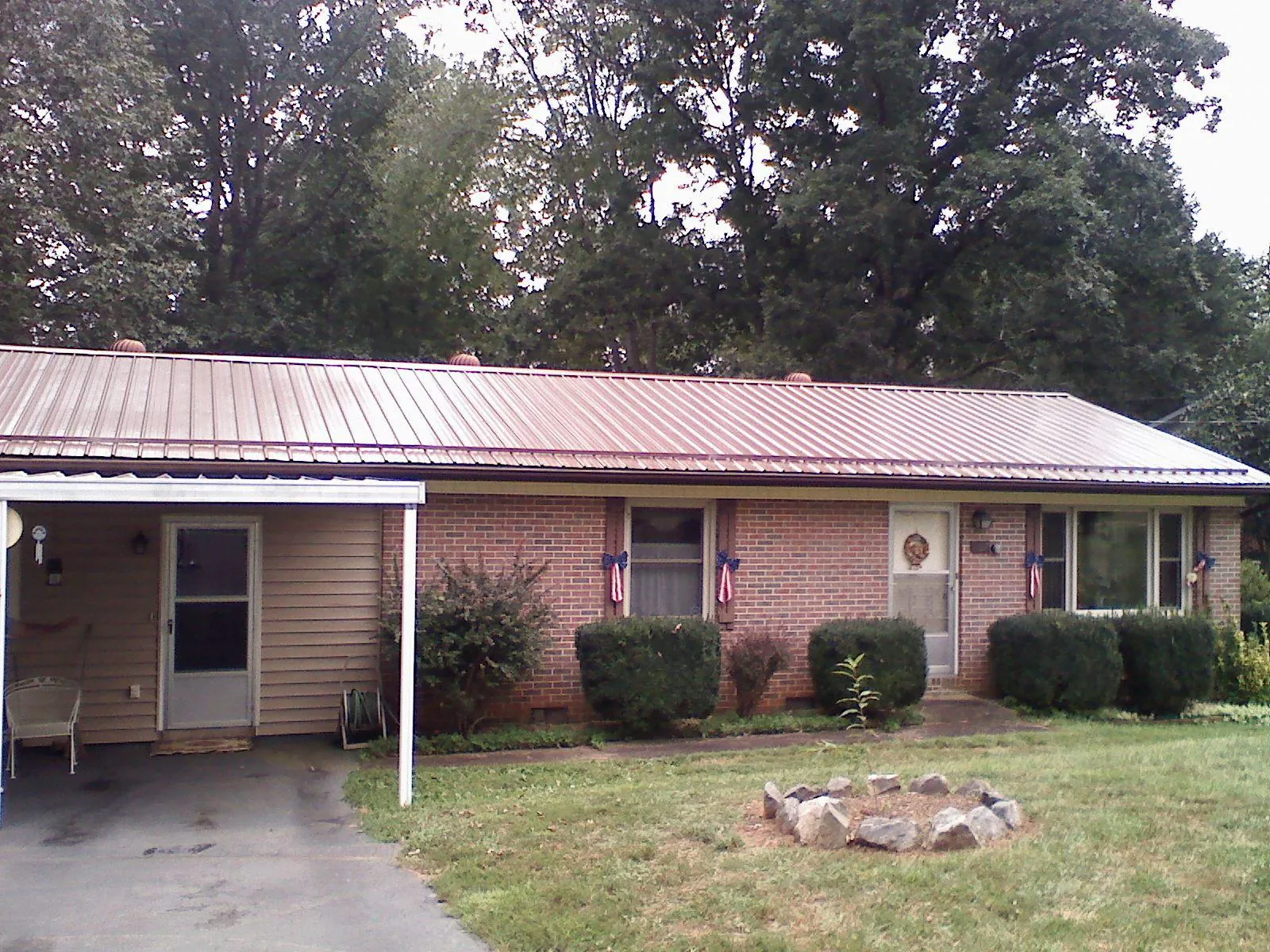 Bronze metal roof and carport on a brick ranch home — Roof Repair work by our crew in Bixby