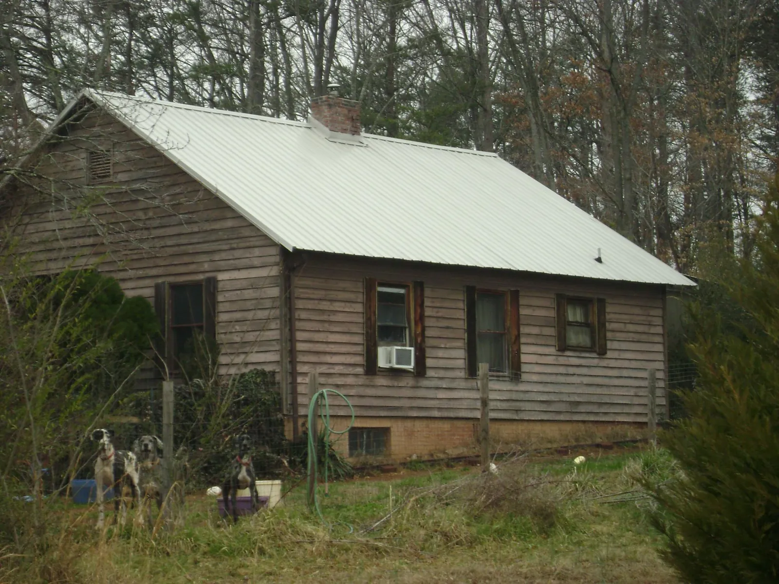 White metal roof on an old wood sided farmhouse, from a Metal Roof Installation job in Bixby